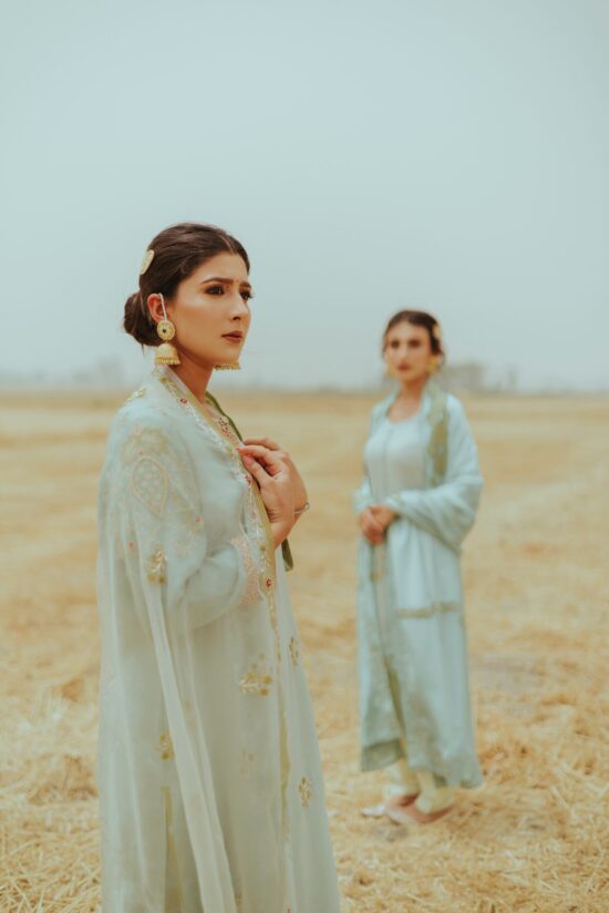 two women standing in a field of dry grass