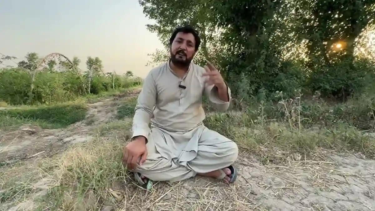 Anjum Saroya sitting outdoors near fields.