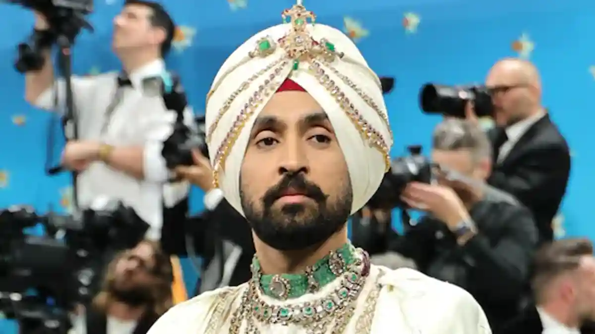 Diljit Dosanjh performing on stage in sunglasses.